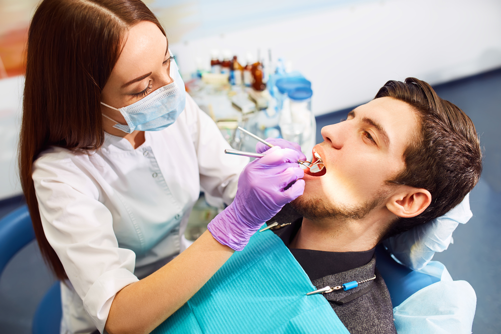 Dentist examining man's teeth